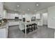 Modern kitchen boasts white cabinets, granite countertops, stainless steel appliances, and a large island at 4610 Point Rock Dr, Buford, GA 30519