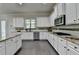 White cabinets and stainless steel appliances accent this open kitchen with a speckled granite island at 4610 Point Rock Dr, Buford, GA 30519