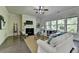 Bright living room with a fireplace, lots of windows, hardwood floors, a ceiling fan, and neutral paint at 4610 Point Rock Dr, Buford, GA 30519