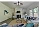 Bright living room features a fireplace, large windows, ceiling fan, and a comfortable seating area at 4610 Point Rock Dr, Buford, GA 30519