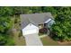 Aerial view of the home, showing the roof, driveway, garage, and mature trees at 5298 Autumn Run Dr, Powder Springs, GA 30127