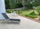 Spacious backyard with a well-maintained lawn, landscaping, lounge chair and patio seating at 5298 Autumn Run Dr, Powder Springs, GA 30127