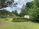 View of a well-manicured backyard with a storage shed, offering ample space for gardening at 5298 Autumn Run Dr, Powder Springs, GA 30127