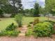 A lush backyard with mature trees and plantings and a stepping stone pathway at 5298 Autumn Run Dr, Powder Springs, GA 30127