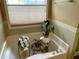 Bright bathroom featuring a garden tub with plants near a window at 5298 Autumn Run Dr, Powder Springs, GA 30127