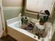 Bright bathroom featuring a garden tub with plants near a window at 5298 Autumn Run Dr, Powder Springs, GA 30127