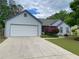 Inviting single-story home featuring an attached garage and beautifully landscaped front yard at 5298 Autumn Run Dr, Powder Springs, GA 30127