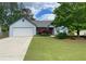 Charming single-story home with well-maintained lawn, attached garage, and inviting curb appeal at 5298 Autumn Run Dr, Powder Springs, GA 30127