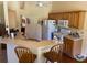 Bright kitchen with a breakfast bar, white appliances, and wood cabinets at 5298 Autumn Run Dr, Powder Springs, GA 30127