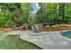 Secluded backyard with a brick outdoor fireplace, and comfortable lounge seating at 5335 Bannergate Dr, Johns Creek, GA 30022