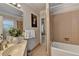 An all-tile bathroom with a soaking tub and vanity at 5335 Bannergate Dr, Johns Creek, GA 30022