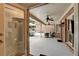 View of the covered patio, showcasing brick walls, ceiling fans, and outdoor seating area at 5335 Bannergate Dr, Johns Creek, GA 30022