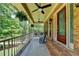 Charming front porch featuring brick accents, rocking chairs, and ceiling fans for relaxed outdoor living at 5335 Bannergate Dr, Johns Creek, GA 30022