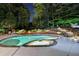 Night view of a beautiful pool with natural landscaping with stone steps leading to an upper tier at 5335 Bannergate Dr, Johns Creek, GA 30022