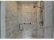 Walk-in shower with marble tiling, a built-in seat, and chrome fixtures at 5335 Bannergate Dr, Johns Creek, GA 30022