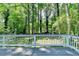 Grey wooden deck with white railing overlooking the lush, green backyard at 6419 Danbury Ln, Norcross, GA 30093