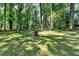 Expansive backyard with mature trees, a trampoline, and a fire pit at 6419 Danbury Ln, Norcross, GA 30093
