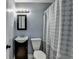 Compact bathroom with black vanity, toilet and shower-tub combination with a gray curtain at 6419 Danbury Ln, Norcross, GA 30093
