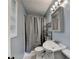 Compact bathroom featuring a shower, window, vanity, and storage shelves at 6419 Danbury Ln, Norcross, GA 30093