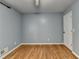 A compact bedroom featuring hardwood floors, neutral walls, and one door at 6419 Danbury Ln, Norcross, GA 30093
