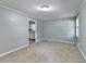 This is a large bedroom with neutral carpet, light gray walls, and a doorway to the kitchen at 6419 Danbury Ln, Norcross, GA 30093