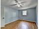 Inviting bedroom with hardwood floors, blue walls, a window, and a ceiling fan at 6419 Danbury Ln, Norcross, GA 30093