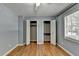 A well lit bedroom with hardwood floors and large closet with bi-fold doors at 6419 Danbury Ln, Norcross, GA 30093