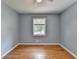 A small bedroom featuring light blue paint, hardwood floors, and one large window at 6419 Danbury Ln, Norcross, GA 30093