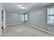 This is a spacious bedroom with neutral carpet, light gray walls, and natural light from windows at 6419 Danbury Ln, Norcross, GA 30093