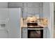 Cozy kitchen area with stainless steel oven, gray cabinets, white refrigerator and views into the living room at 6419 Danbury Ln, Norcross, GA 30093