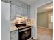 Kitchen includes gray cabinets, stainless steel appliances, tile backsplash and an open view of the living room at 6419 Danbury Ln, Norcross, GA 30093