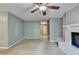 Open living room with neutral paint, ceiling fan and access to a fireplace and staircase at 6419 Danbury Ln, Norcross, GA 30093