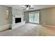 Spacious living room features a white brick fireplace, large window with backyard view and a ceiling fan at 6419 Danbury Ln, Norcross, GA 30093
