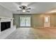 Living room includes a white brick fireplace, large window with backyard view and a ceiling fan at 6419 Danbury Ln, Norcross, GA 30093
