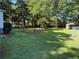 Large grassy backyard offering a serene outdoor space with shade trees and a storage shed at 1215 Sheppard Pl, Stone Mountain, GA 30083