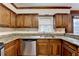 Traditional kitchen boasting wood cabinets, stainless steel dishwasher, and granite countertops by the window at 478 Guilford Cir, Marietta, GA 30068