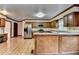 Well-lit kitchen showcasing stainless steel appliances, a breakfast bar, and wood cabinets with hardwood floors at 478 Guilford Cir, Marietta, GA 30068