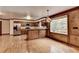 Open kitchen with wood cabinets, stainless steel appliances, granite countertops, wood-paneled walls, and hardwood floors at 478 Guilford Cir, Marietta, GA 30068