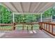 Covered wooden patio with a built-in bench overlooking a lush, green backyard at 478 Guilford Cir, Marietta, GA 30068