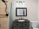 Bathroom featuring dark vanity, a shower with tan tile, and decorative mirror at 1125 Murray Sw Cir, Marietta, GA 30064