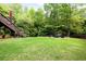 Spacious backyard featuring a lush green lawn and a cozy seating area with a swing at 417 Rhodes House Dr, Suwanee, GA 30024
