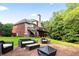 Patio and backyard with outdoor seating, lush lawn, and mature trees at 417 Rhodes House Dr, Suwanee, GA 30024