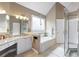 Bright bathroom with granite countertops, soaking tub and glass enclosed shower at 417 Rhodes House Dr, Suwanee, GA 30024