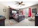 Cozy bedroom with ceiling fan, dark wood furniture and bright red accents at 417 Rhodes House Dr, Suwanee, GA 30024
