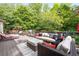 Spacious deck with an outdoor sofa, chairs, a grill, and a lush green backdrop at 417 Rhodes House Dr, Suwanee, GA 30024