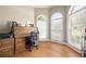 Bright home office with hardwood floors, arched windows, and a classic roll-top desk at 417 Rhodes House Dr, Suwanee, GA 30024