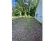Side view of a fenced backyard featuring lush green grass, trees, and a home with white siding at 5028 Highway 81, Mcdonough, GA 30252