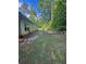 Fenced backyard with stone pavers, lush greenery, and a view of the home's exterior at 5028 Highway 81, Mcdonough, GA 30252
