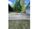 Concrete driveway next to lush trees and greenery with views of the attached garage at 5028 Highway 81, Mcdonough, GA 30252