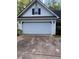 Attached two-car garage with a white paneled door, exterior lighting, and a concrete driveway at 5028 Highway 81, Mcdonough, GA 30252